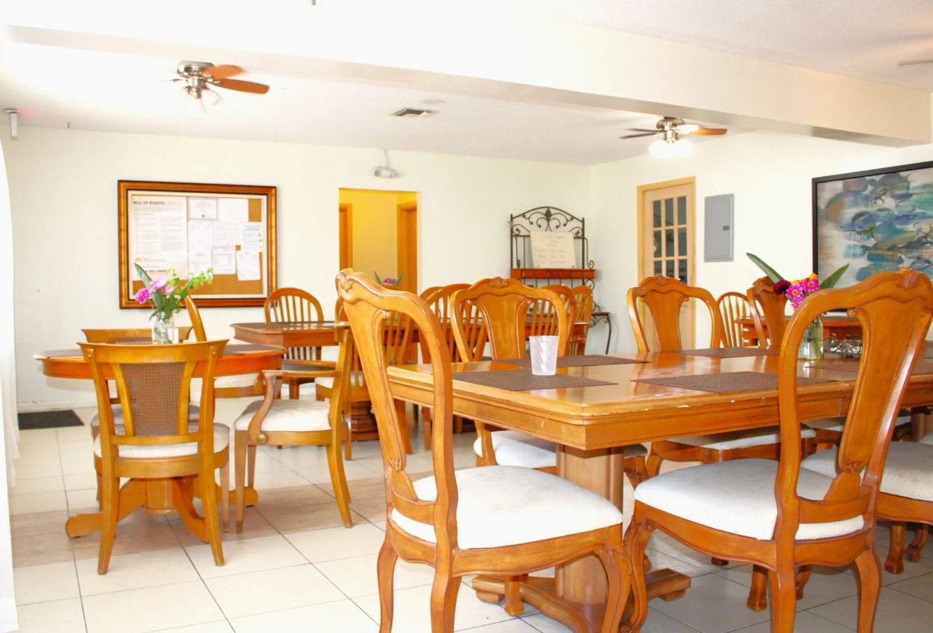 The dining room, with wooden tables set with flowers.